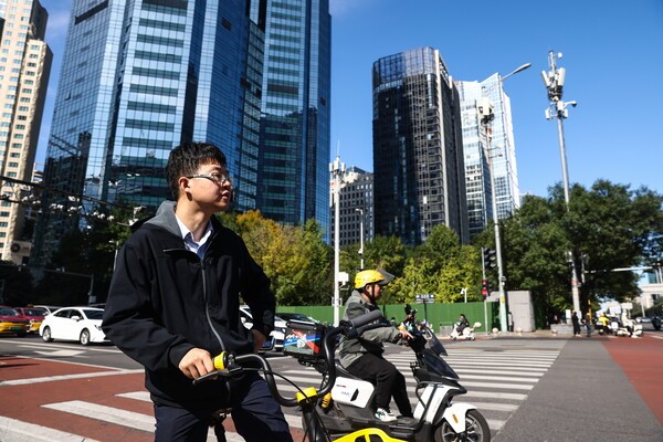 중국 경제가 1년 만에 가장 느린 성장세를 기록했다. 베이징 중심상업지구(CBD)에서 한 남성이 자전거를 타고 있다. [출처=연합뉴스]