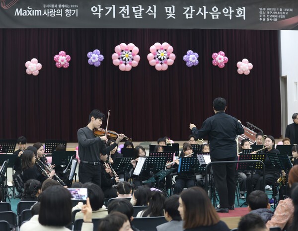 유명 바이올리니스트 대니 구(Danny Koo)와 대구시립교향악단 단원들이 지난 13일 대구서부초등학교에서 열린 ‘제18회 맥심 사랑의 향기’ 행사에서 합주 공연을 펼치고 있다. [출처=동서식품]