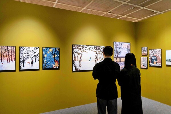 잠실점 아트홀에서 진행하는 '겨울, 그 따뜻한 순간들' 전시를 관람하고 있는 고객들 모습. [출처=롯데백화점]